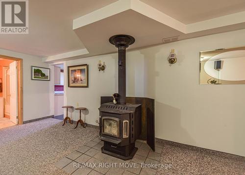 Wood fireplace on lower level - 2723 Monck Road, Ramara, ON - Indoor Photo Showing Other Room