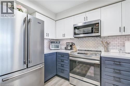 Kitchen featuring appliances with stainless steel finishes, white cabinetry, and decorative backsplash - 3845 Lakeshore Boulevard W Unit# 804, Etobicoke, ON - Indoor Photo Showing Kitchen With Stainless Steel Kitchen