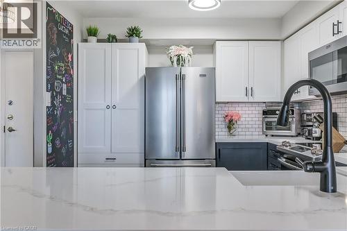 Kitchen with white cabinets, appliances with stainless steel finishes, light stone countertops, tasteful backsplash, and gray cabinets - 3845 Lakeshore Boulevard W Unit# 804, Etobicoke, ON - Indoor Photo Showing Kitchen