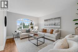 Bright living room with large windows and open sightlines. - 