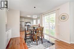 Dining area featuring light wood-style flooring and a chandelier - 