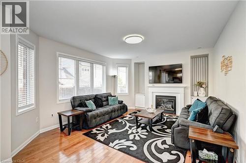 Living room featuring light wood-type flooring and a glass covered fireplace - 32 Weir Street, Cambridge, ON - Indoor Photo Showing Living Room With Fireplace