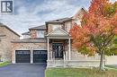 View of front of property featuring asphalt driveway, stone siding, a front lawn, and an attached garage - 32 Weir Street, Cambridge, ON  - Outdoor With Facade 