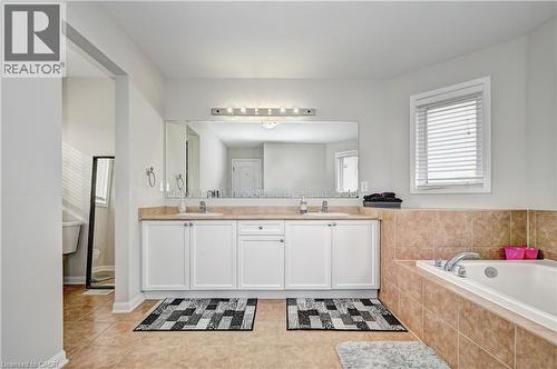 Bathroom featuring a bath, double vanity, and light tile patterned floors - 32 Weir Street, Cambridge, ON - Indoor Photo Showing Bathroom