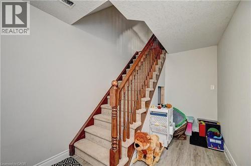 Stairs with wood finished floors and a textured ceiling - 32 Weir Street, Cambridge, ON - Indoor Photo Showing Other Room