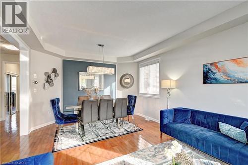 Dining area featuring a tray ceiling, wood finished floors, and a chandelier - 32 Weir Street, Cambridge, ON - Indoor Photo Showing Living Room