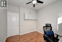 Unfurnished office with light wood-style floors and a ceiling fan - 