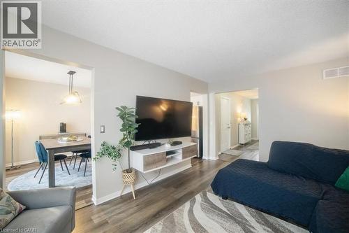Living area with wood finished floors and a textured ceiling - 25 Meadowvale Drive Unit# 3, Fonthill, ON - Indoor Photo Showing Living Room