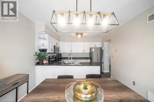 Kitchen featuring stainless steel appliances, white cabinetry, decorative light fixtures, a peninsula, and open shelves - 25 Meadowvale Drive Unit# 3, Fonthill, ON - Indoor