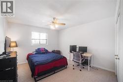 Bedroom with a desk, light colored carpet, a ceiling fan, and a textured ceiling - 