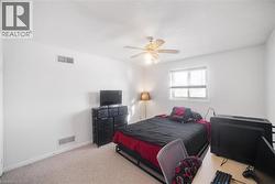 Carpeted bedroom with a textured ceiling and a ceiling fan - 