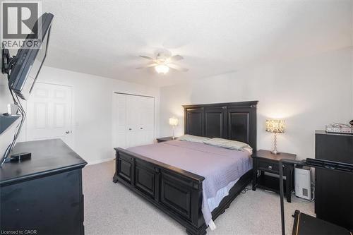 Bedroom with light colored carpet, a closet, ceiling fan, and a textured ceiling - 25 Meadowvale Drive Unit# 3, Fonthill, ON - Indoor Photo Showing Bedroom