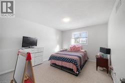 Bedroom featuring light colored carpet and a textured ceiling - 
