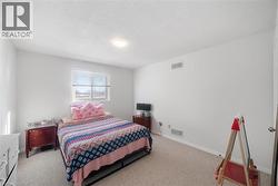 Carpeted bedroom featuring a textured ceiling and baseboards - 
