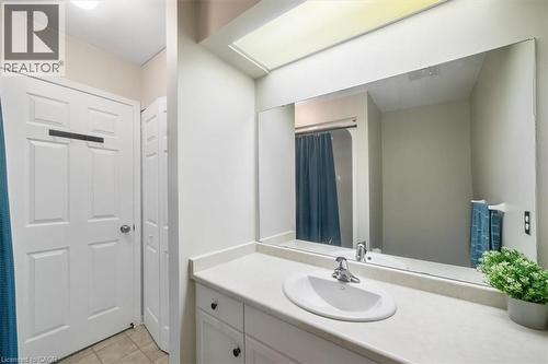Bathroom featuring vanity, light tile patterned floors, and a shower with shower curtain - 25 Meadowvale Drive Unit# 3, Fonthill, ON - Indoor Photo Showing Bathroom