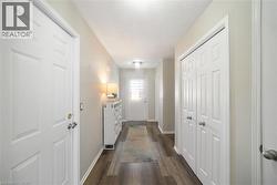 Hall featuring a textured ceiling and dark wood-style floors - 