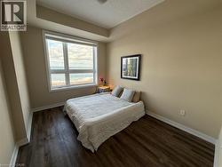 Bedroom with a textured ceiling and dark wood-style flooring - 