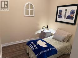 Bedroom featuring wood finished floors and baseboards - 