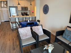 Living room featuring dark wood-style flooring and baseboards - 