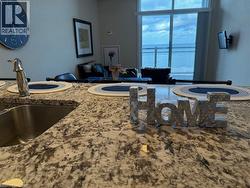 Kitchen with light stone countertops and open floor plan - 