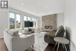 Living area with a fireplace, recessed lighting, and wood finished floors - 