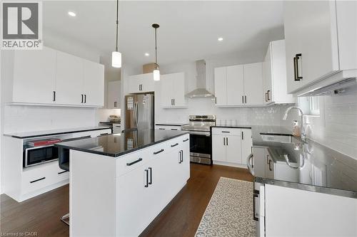Kitchen featuring decorative light fixtures, stainless steel appliances, wall chimney range hood, a center island, and dark wood-style flooring - 7266 Silver Creek Circle, London, ON - Indoor Photo Showing Kitchen With Upgraded Kitchen