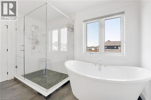 Bathroom with a marble finish shower, a freestanding tub, and dark wood-style floors - 7266 Silver Creek Circle, London, ON - Indoor Photo Showing Bathroom