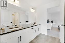Bathroom featuring double vanity and light colored carpet - 