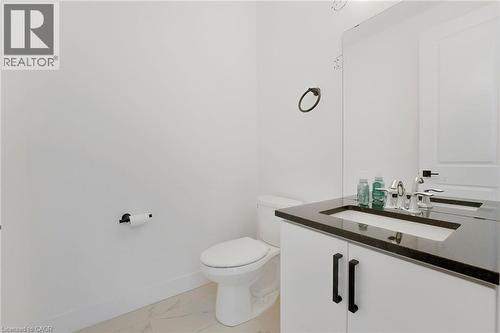 Half bath with vanity and light marble finish flooring - 7266 Silver Creek Circle, London, ON - Indoor Photo Showing Bathroom