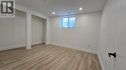 Basement with light wood finished floors and recessed lighting - 