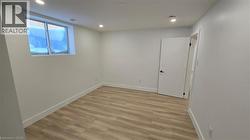 Empty room with light wood finished floors and recessed lighting - 