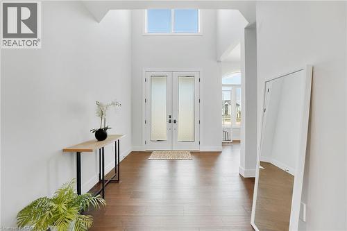 Entrance foyer with healthy amount of natural light, french doors, a high ceiling, and dark wood-type flooring - 7266 Silver Creek Circle, London, ON - Indoor Photo Showing Other Room