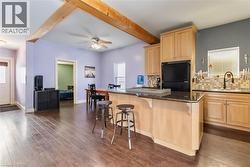 Kitchen with light brown cabinets, decorative backsplash, a center island, freestanding refrigerator, and beam ceiling - 