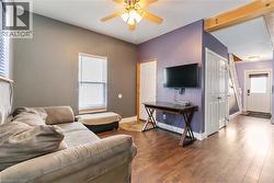 Living room featuring wood type floors and a ceiling fan - 