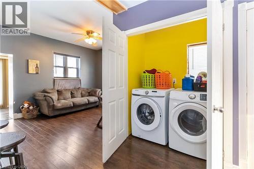 Laundry area with dark wood-style floors, a ceiling fan, and separate washer and dryer - 112 Eagle Avenue, Brantford, ON - Indoor Photo Showing Laundry Room