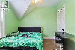 Bedroom with vaulted ceiling, carpet flooring, and ceiling fan - 