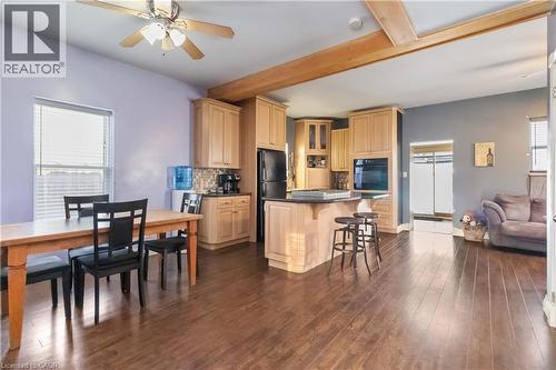 Kitchen featuring dark countertops, ceiling fan, a breakfast bar, light brown cabinets, and a center island - 112 Eagle Avenue, Brantford, ON - Indoor