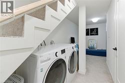 Laundry area with light carpet and washing machine and clothes dryer - 