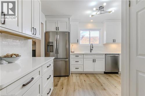 Kitchen with appliances with stainless steel finishes, white cabinetry, light wood-style floors, backsplash, and recessed lighting - 5 Newport Lane, Port Dover, ON - Indoor Photo Showing Kitchen With Upgraded Kitchen