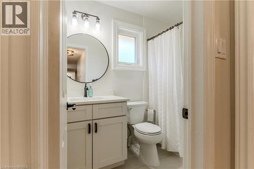 Full bath with curtained shower, vanity, and light tile patterned floors - 5 Newport Lane, Port Dover, ON - Indoor Photo Showing Bathroom