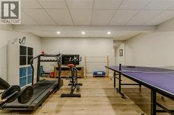 Workout room featuring a drop ceiling, wood finished floors, and recessed lighting - 