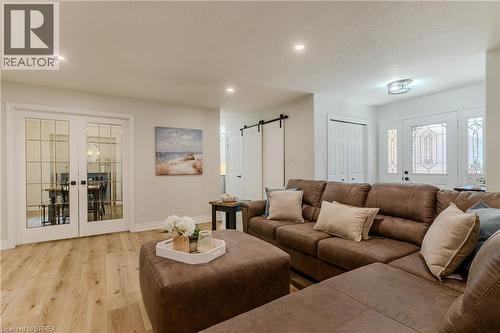 Living area with a barn door, wood finished floors, french doors, and recessed lighting - 5 Newport Lane, Port Dover, ON - Indoor Photo Showing Living Room