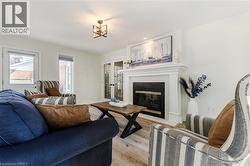 Living room with a fireplace with flush hearth, wood finished floors, and french doors - 