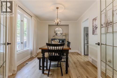 Dining area with a chandelier, ornamental molding, and light wood-style floors - 5 Newport Lane, Port Dover, ON - Indoor Photo Showing Dining Room