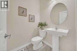 Bathroom featuring toilet and marble finish floors - 