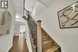 Staircase with healthy amount of natural light, wood finished floors, and a towering ceiling - 