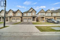 View of front of home featuring driveway, brick siding, and a garage - 