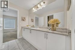 Bathroom with vanity, light carpet, and light marble finish flooring - 
