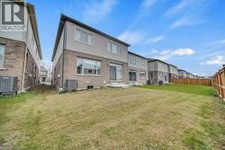 Back of house with a fenced backyard, brick siding, and a residential view - 