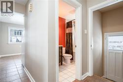 Hall with light tile patterned flooring and baseboards - 